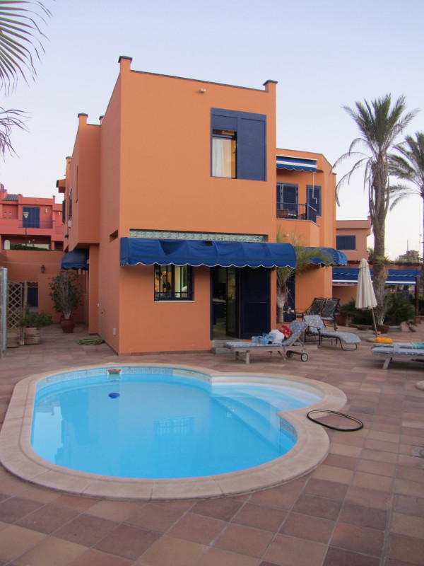 SykkelKomplekset™ som viser uteområde, Frodolini sitt soverom opp til venstre samt mitt soverom og balkong oppe til høyre. Den vindskeive parasollen har tydeligvis vært ute en vinternatt før, alternativt var det utrolig mye vind da fotografen var ute på oppdrag tidligere i dag. Til venstre har vi grillområdet, og kjøkkenet befinner seg beint fram.Vi beklager at det helvetes bakdekket mitt kom med på bildet. Etter å ha brukt 43 minutter på å rive det av felgen var jeg så forbanna at jeg kasta det i bassenget, men noen har tydeligvis fisket det opp. Mer om det senere.